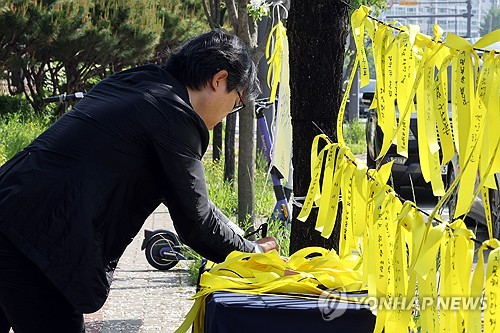 추모 메시지 적는 시민
(광주=연합뉴스) 김혜인 기자 = 지난 7일 고교생 흉기 살인사건이 발생한 광주 광산구 월계동 현장에 마련된 추모공간에서 한 시민이 노란 리본에 애도 메시지를 적고 있다. 2026.5.14