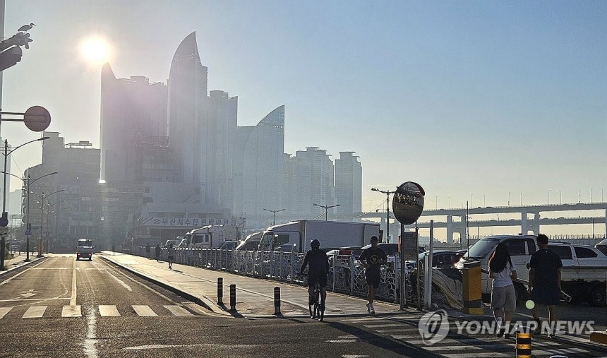 아침부터 뜨거운 부산 (부산=연합뉴스) 강선배 기자 = 연일 폭염과 열대야가 이어진 30일 오전 부산 수영구 민락수변로에서 시민들이 강한 햇볕을 받으며 이동하고 있다. 아침부터 내리쬐는 햇살에 도심이 역광으로 물들어