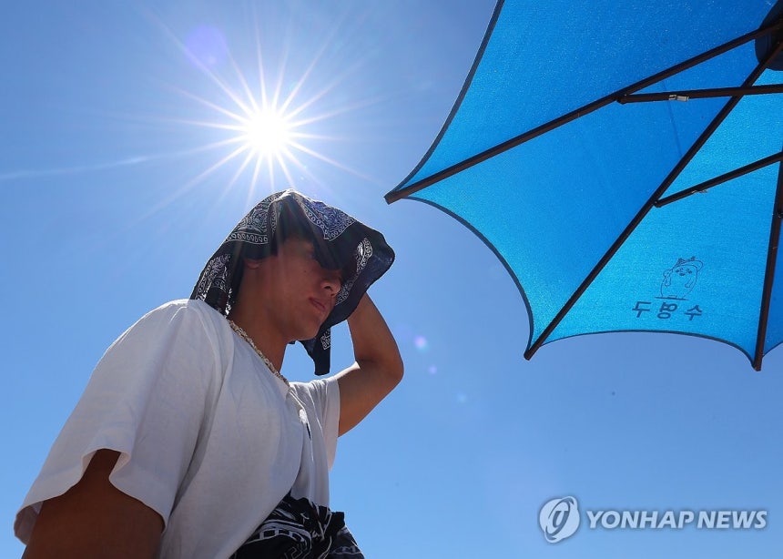 태양을 피해 (부산=연합뉴스) 손형주 기자 = 30일 부산 수영구 광안리해수욕장을 찾은 피서객이 손수건을 머리에 올려 태양을 피하고 있다. 2026.7.30 handbrother@yna.co.kr