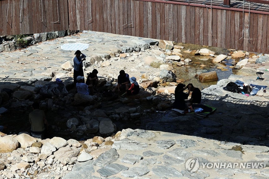 그늘로 모인 사람들 (공주=연합뉴스) 양영석 기자 = 충남 일부 지역에 폭염중대경보가 내려진 5일 오후 충남 공주 계룡산 계곡을 찾은 시민들이 그늘 아래 모여 더위를 식히고 있다.2026.8.5 youngs@yna