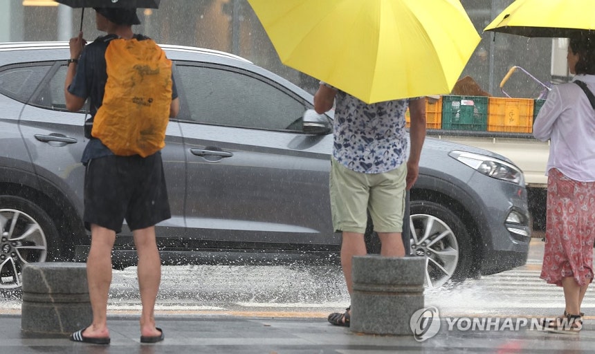 폭우에 튀는 빗물 (부산=연합뉴스) 강선배 기자 = 28일 부산 해운대해수욕장 인근 횡단보도에서 관광객들이 우산을 쓰고 신호를 기다리고 있다.2026.8.28 