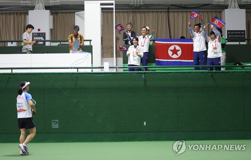 남북 대결…북한 리진미 승리(히가시야마[일본]=연합뉴스) 김동민 기자 = 23일 일본 히가시야마공원 테니스센터에서 열린 2026 아이치·나고야 아시안게임 정구 여자 단식 8강 한국 황정미와 북한 리진미의 경기. 북한 리지민이 승리 후 이동하자 북측 관계자가 기뻐하고 있다. 2026.9.23 image@yna.co.kr