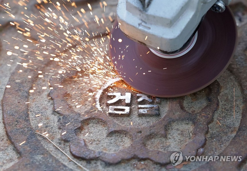 지워지는 검찰 마크
(서울=연합뉴스) 류영석 기자 = 공소청 출범을 사흘 앞둔 29일 서울 서초구 대검찰청에서 작업자들이 맨홀 뚜껑에 새겨진 검찰 마크를 지우고 있다. 2026.9.29 ondol@yna.co.kr