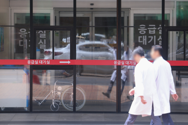▲정부가 중증·응급환자의 진료공백을 최소화하기 위해 현장 의료진에 대한 지원을 강화하고, 경증 환자를 지역 병의원으로 분산하는 대책을 발표한 22일 오후 의료진이 서울 시내 한 대형병원 응급실 대기실 앞을 지나치고 