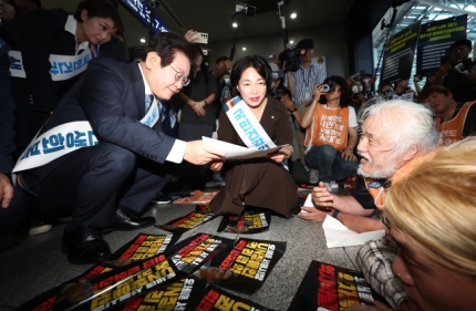 ▲더불어민주당 이재명 대표가 13일 오전 서울 용산역에서 추석 귀성인사를 하던 도중 박경석 전국장애인차별철폐연대(전장연) 대표로부터 7대 장애인권리입법 내용이 담긴 서류를 받고 있다. ⓒ연합뉴스