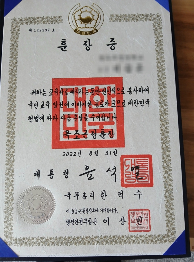 ▲전주 소통행사에서 한 어르신이 이성윤 의원에게 보여준 딸의 훈장증 사진. ‘대통령 윤석열, 국무총리 한덕수, 행정안전부 장관 이상민’ 이름이 함께 새겨져 있다. ⓒ독자 제공
