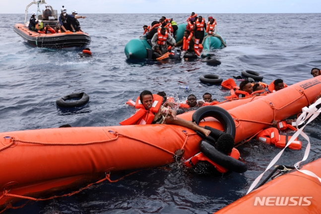 [리비아해역=AP/뉴시스] 리비아 해안에서56km떨어진 지중해에서 고무보트를 타고 유럽을 향해 가다가 조난한 난민들이 리비아 해양경찰에 의해 구조되는 광경( 2021년 10월 18일 AP자료사진). 2024.04. 
