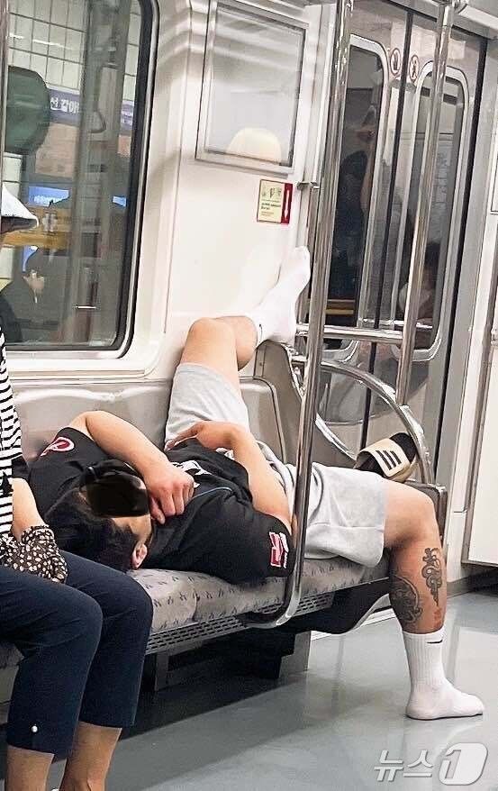 문신을 한 남성이 6호선 지하철에서 좌석 3개를 차지한 채 드러누워 잠을 자고 있다. (사진=온라인 커뮤니티 캡쳐) *재판매 및 DB 금지