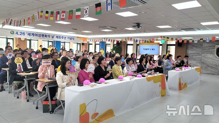 사진설명= 제6주년 세계여성평화의 날 기념식 후 토퍼를 들고 단체 기념촬영을 하고 있다.(사진= ㈔세계여성평화그룹 제공) 2025.04.27.