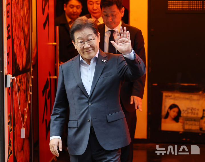 [서울=뉴시스] 조성우 기자 = 이재명 더불어민주당 대선후보가 1일 오후 서울 종로구의 한 포장마차에서 열린 비전형 노동자 간담회를 마치고 나오며 손을 들어 보이고 있다.대법원 전원합의체는 이날 이 후보에게 무죄를
