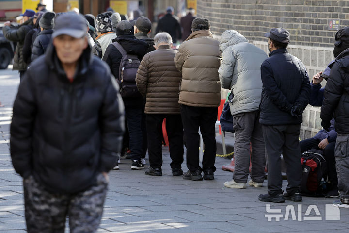 [서울=뉴시스] 최동준 기자 = 지난해 12월 24일 서울 종로구 탑골공원 앞 무료급식소에서 어르신들이 줄을 서고 있다.2024.12.24.