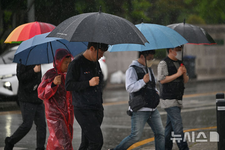 [광주=뉴시스] 이영주 기자 = 광주지역에 비가 내리는 1일 오후 광주 서구 광주시청 앞에서 시민들이 우산을 쓴 채 횡단보도를 건너고 있다.2025.05.01.