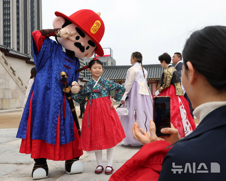 [서울=뉴시스] 조수정 기자 = 103주년 어린이날인 5일 서울 종로구 경복궁 광화문에서 한 어린이가 수문장 어린이날 특별행사로 열린 인형탈 파수의식을 관람한 뒤 함께 기념촬영 하고 있다.2025.05.03.ch