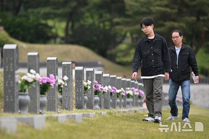 [광주=뉴시스] 이영주 기자 = 5·18민주화운동 45주기를 12일 앞둔 6일 오전 광주 북구 운정동 국립5·18민주묘지에서 한 아이가 묘지를 거닐며 5·18 희생자들의 묘비를 살피고 있다.2025.05.06.l