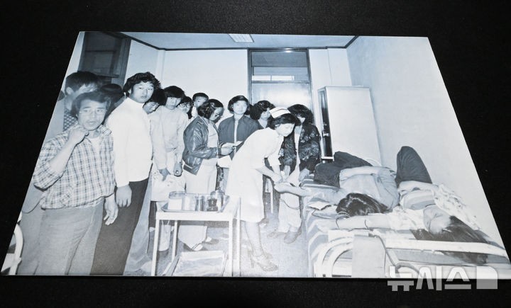 [광주=뉴시스] 이영주 기자 = 6일 오후 광주 동구 옛적십자병원에서 이창성 전 중앙일보 기자가 5·18 당시 촬영했던 병원 내 헌혈 장면이 담긴 사진이 전시되고 있다.옛적십자병원은 5·18민주화운동 45주기를 