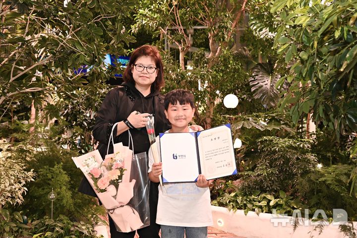 [부천=뉴시스] 정일형 기자 = 정태운 군과 그의 어머니가 부천시로부터 모범 어린이 표창장을 받은 뒤 환하게 웃고 있다.(사진=부천시 제공)