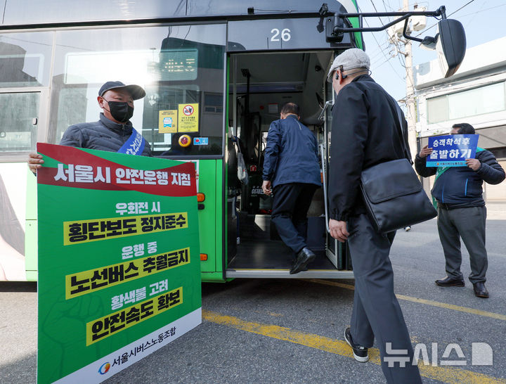 [서울=뉴시스] 김진아 기자 = 사측과의 임금·단체협약 협상이 결렬된 서울 시내버스 노조가 준법 투쟁을 재개한 7일 서울 성동구 태진운수 앞에서 노조원들이 교섭 타결을 촉구하며 안전운행이 적힌 손팻말을 들고 있다.