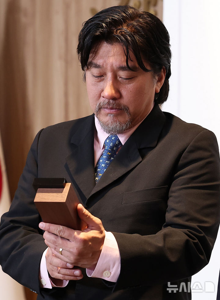 [서울=뉴시스] 정병혁 기자 = 서울시 홍보대사로 위촉된 에드워드 리 셰프가 7일 서울 중구 서울시청 집무실에서 열린 위촉식에서 위촉패를 바라보고 있다.(공동취재) 2025.05.07.