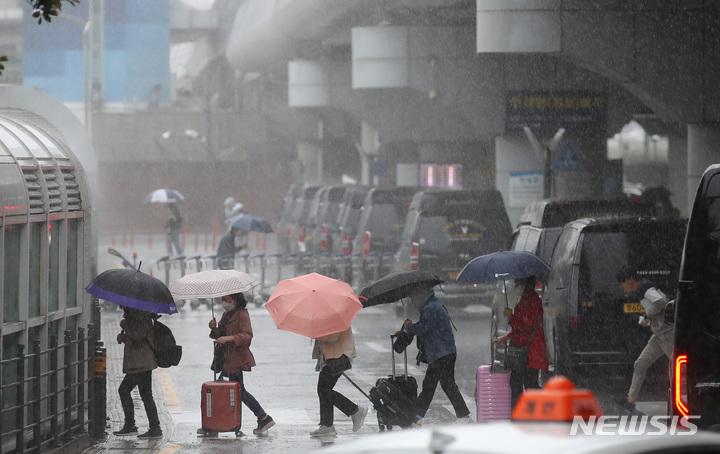 [제주=뉴시스] 우장호 기자 = 제주국제공항 1층 도착장에 우산을 쓴 관광객들이 발걸음을 재촉하고 있다.(사진=뉴시스DB) 