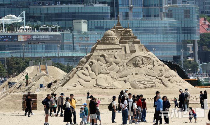 [부산=뉴시스] 하경민 기자 = 황금연휴 기간인 4일 부산 해운대구 해운대해수욕장을 찾은 시민과 관광객들이 다양한 모래조각 작품을 구경하고 있다.해운대구는 오는 16~19일 '2025년 해운대 모래축제'를 개최한