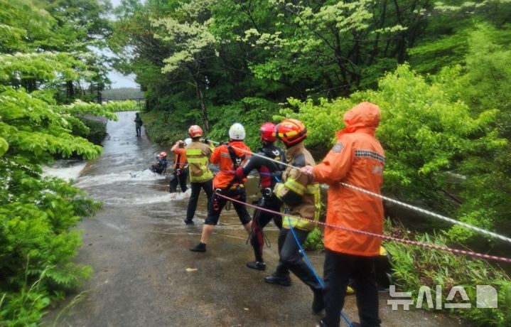 [제주=뉴시스] 9일 오전 제주시 조천읍에서 침수된 도로로 인해 고립된 고사리객이 소방당국에 의해 구조되고 있다.(사진=제주소방안전본부 제공) 2025.05.09.