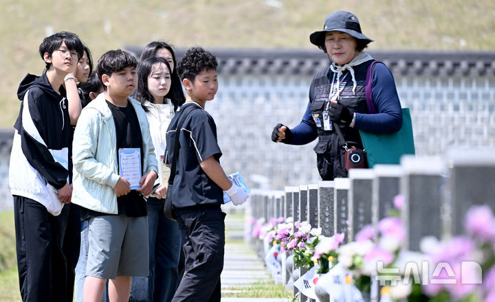 [광주=뉴시스] 김혜인 기자 = 광주 5·18민주화운동 45주년 엿새를 앞둔 12일 오전 광주 북구 국립 5·18민주묘지에서 학생들이 해설사로부터 희생자에 대한 설명을 듣고 있다.2025.05.12.hyein03