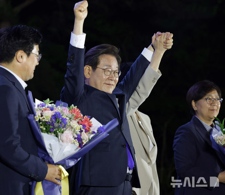 [서울=뉴시스] 조성우 기자 = 이재명 대통령이 4일 오전 서울 여의도 국회 앞에서 열린 국민 개표방송 행사에서 꽃다발을 받은 뒤 시민들을 향해 인사하고 있다.(공동취재) 2025.06.04. photo@newsis