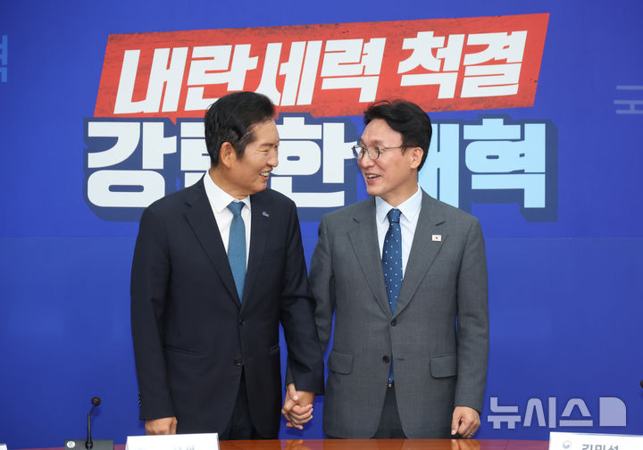 [서울=뉴시스] 고승민 기자 = 김민석(오른쪽) 국무총리가 5일 서울 여의도 국회 더불어민주당을 예방, 정청래 대표와 함께 손을 잡고 기념촬영하고 있다. 2025.08.05. kkssmm99@newsis.com