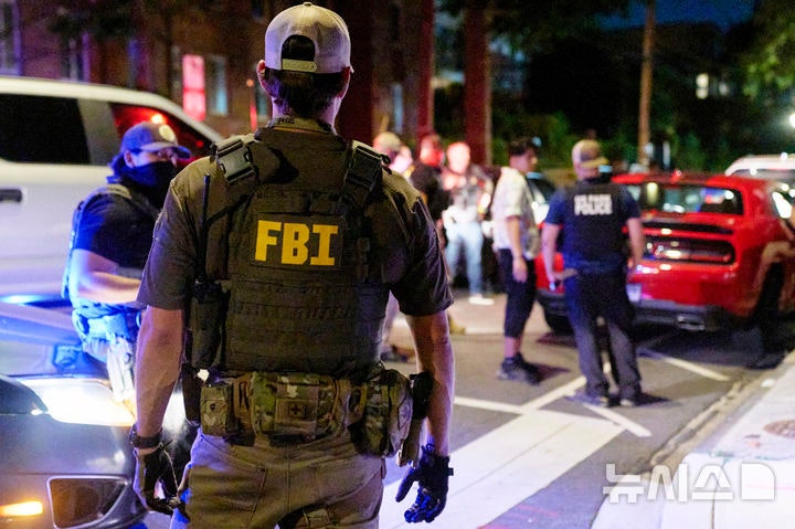 [AP/뉴시스] 12일 밤 미 수도 워싱턴 거리에서 연방 정부의 BATFE(주류 담배 총기 폭발물 단속국), FBI, 국립공원 경찰국 소속 요원들이 한 커플에게 뭔가 묻고 있다