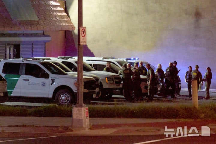 [AP 뉴시스] 13일 새벽 워싱턴 남서구 거리에서 수도 경찰국 경찰과 연방의 세관국경보호국(CBP) 요원들이 같이 서 있다