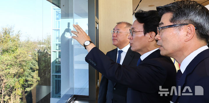 [화성=뉴시스] 박주성 기자 = 김민석 국무총리(가운데)와 정의선 현대차그룹 회장(왼쪽), 송호성 기아차 사장이 14일 경기도 화성시 우정읍 기아오토랜드 화성 내 화성대에서 미래차 산업전략 대회 전 공장 전경을 보며