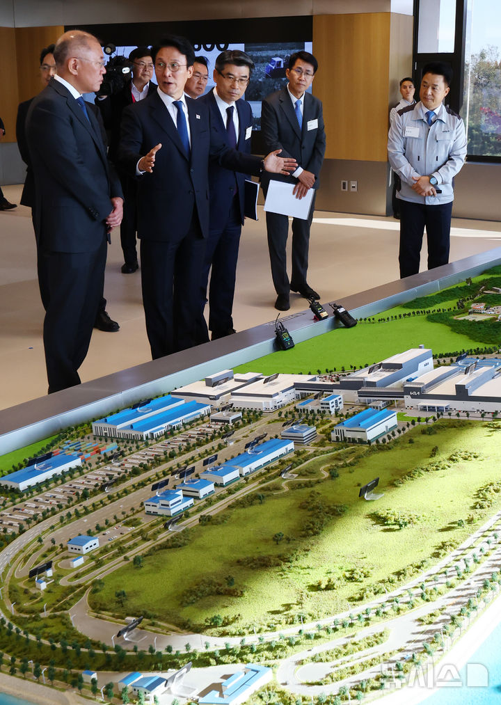 [화성=뉴시스] 박주성 기자 = 김민석 국무총리와 정의선 현대차그룹 회장이 14일 경기도 화성시 우정읍 기아오토랜드 화성 내 화성대에서 미래차 산업전략 대화 전 공장 전경 모형을 보며 이야기를 나누고 있다. 2025