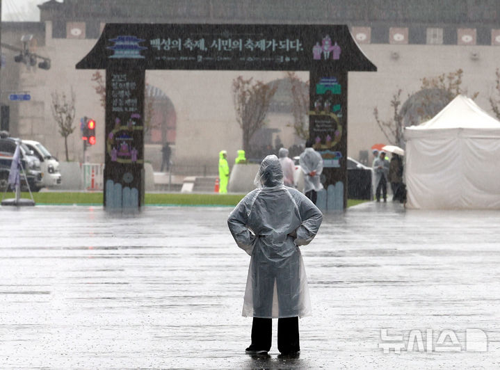[서울=뉴시스] 박주성 기자 = 전국적으로 비가 내린 28일 서울 광과문 광장에 시민이 우비를 입고 이동하고 있다.2025.09.28.