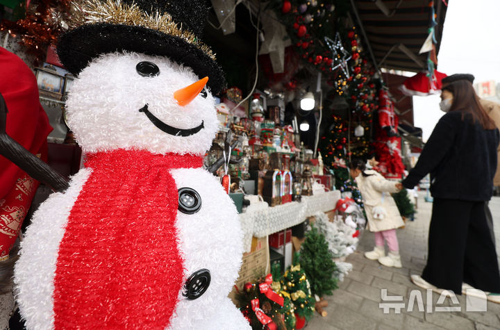 [서울=뉴시스] 홍효식 기자 = 크리스마스를 한 달여 앞둔 23일 서울 중구 남대문시장에서 한 어린이가 엄마 손을 꼭 잡고 크리스마스 장식 용품들을 구경하고 있다.2025.11.23.yesphoto@newsis.