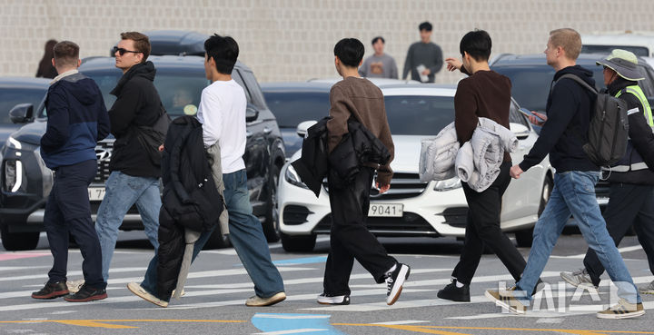 [서울=뉴시스] 김명원 기자 = 일요일인 30일 낮 최고기온이 20도까지 오르는 등 포근한 날씨가 이어지는 가운데 서울 종로구 광화문 광장에 나들이 나온 시민들이 한손에 겨울 외투를 벗어 들고 이동하고 있다.기상청