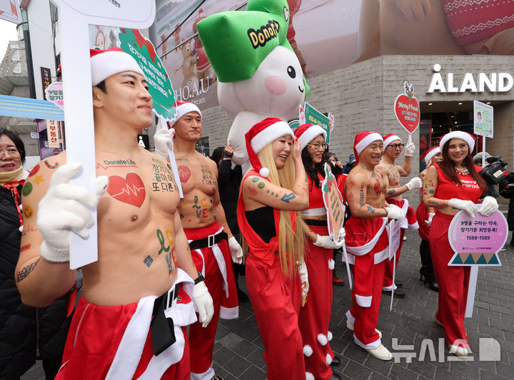 [서울=뉴시스] 배훈식 기자 = 산타 복장을 한 스포츠 트레이너들이 19일 오전 서울 중구 명동거리에서 사랑의장기기증운동본부 '나인퍼레이드'를 하고 있다.'놔사 시 장기기증으로 9명의 생명을 구한다'는 의미를 담은