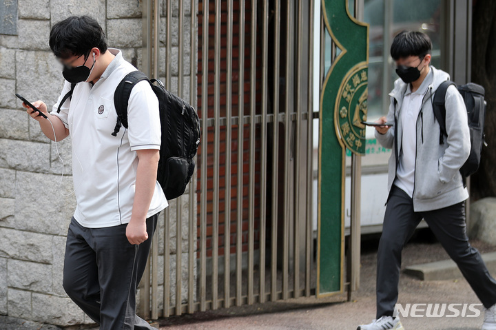 [서울=뉴시스] 백동현 기자 = 25일 오후 서울 시내 한 중학교 앞에서 학생들이 스마트폰을 보면서 하교하고 있다.2022.05.25.**기사 내용과 관련 없습니다**