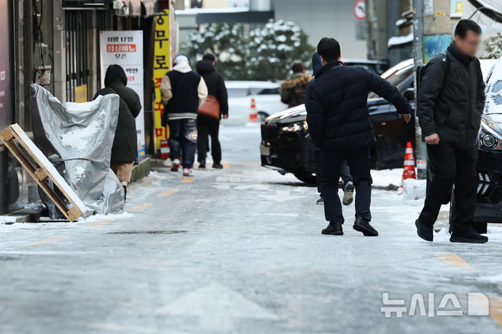 [서울=뉴시스] 권창회 기자 = 폭설 후 한파로 도로 곳곳이 얼어붙은 5일 오전 서울 중구 충무로역 인근에서 시민들이 빙판길을 조심히 걷고 있다.2025.12.05.