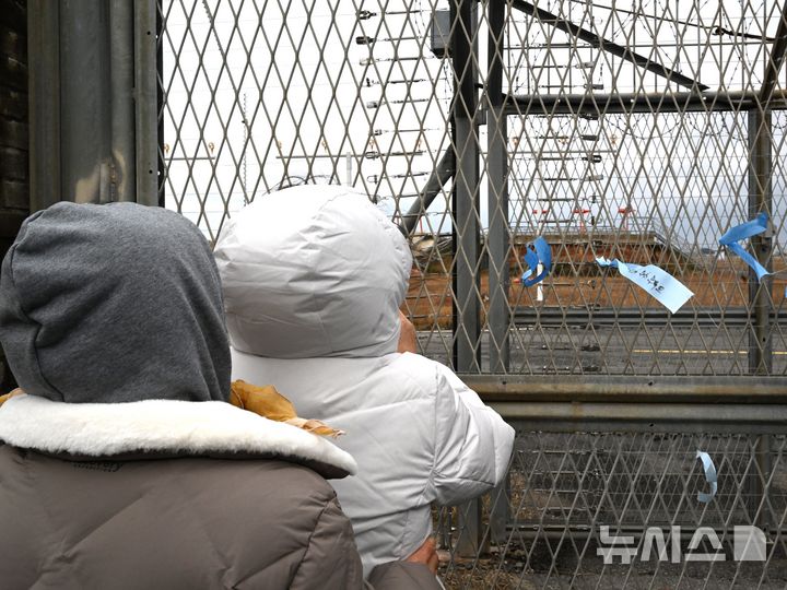 [무안=뉴시스] 이현행 기자 = 12·29 무안공항 제주항공 여객기 참사 유가족들이 24일 오후 전남 무안군 무안국제공항에서 여객기 사고 현장을 바라보고 있다.2025.12.24.