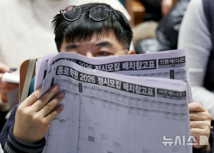 [서울=뉴시스] 김진아 기자 = 7일 서울 종로구 성균관대학교 600주년 기념관에서 열린 종로학원 주최 2026 정시 합격 가능선 예측 및 지원전략 설명회에서 참석자들이 배치표를 살펴보고 있다.2025.12.07.
