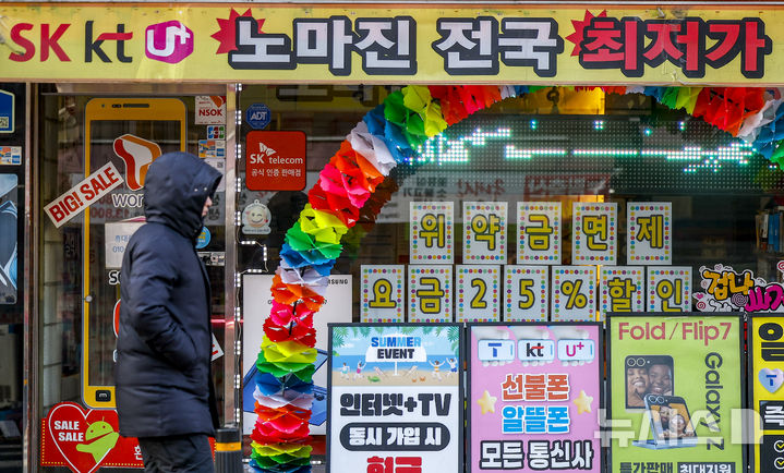 [서울=뉴시스] 정병혁 기자 = 지난 4일 서울시내 휴대폰판매점 앞에서 시민들이 이동하고 있다.2026.12.04.