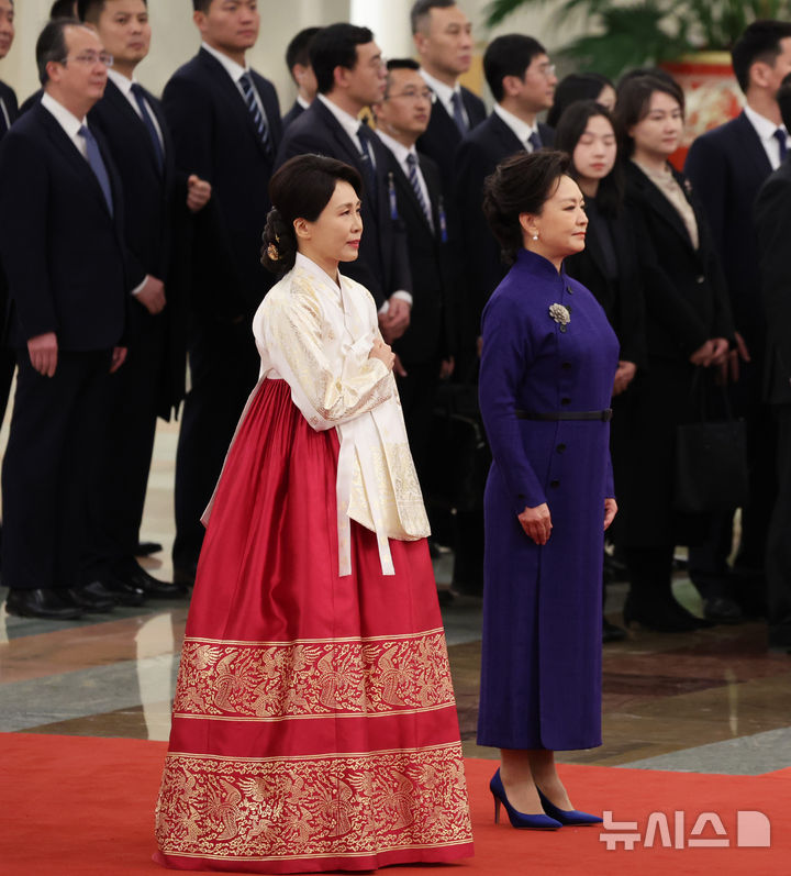 [베이징=뉴시스] 최동준 기자 = 이재명 대통령과 함께 중국을 국빈 방문한 김혜경 여사가 5일(현지 시간) 베이징 인민대회당에서 열린 공식환영식에서 국기에 경례하고 있다. 2026.01.05. photocdj@new