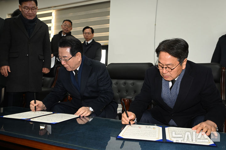[광주=뉴시스] 이영주 기자 = 강기정(오른쪽) 광주시장과 김영록 전남도지사가 2일 오전 광주 국립5·18민주묘지에서 시도통합 선언문에 서명하고 있다.2026.01.02.