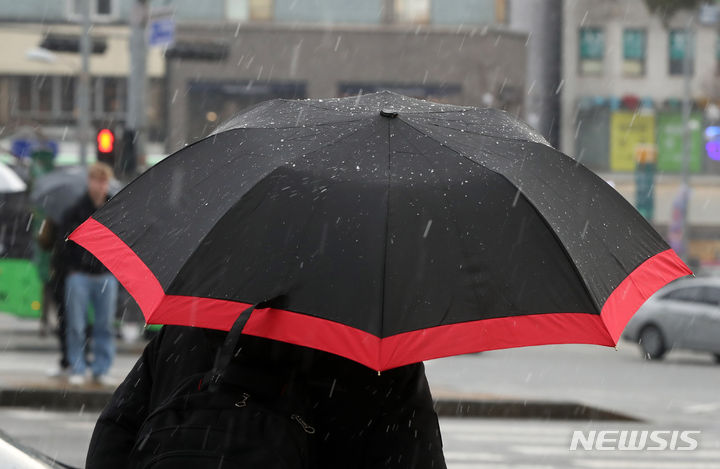 [서울=뉴시스] 김혜진 기자 = 비를 동반한 눈이 내리는 7일 오후 서울 마포구 한 거리에서 시민들이 이동하고 있다.2024.03.07.