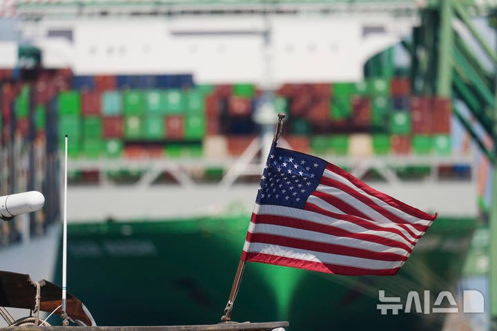 [로스앤젤레스=AP/뉴시스] 전 세계를 상대로 한 관세는 글로벌 시장을 흔들었지만,아직 미국 내 인플레이션을 급격히 끌어올리지는 않았다.사진은 미국 캘리포니아 로스앤젤레스 항구의 컨테이너선 앞에 미국 국기가 걸려