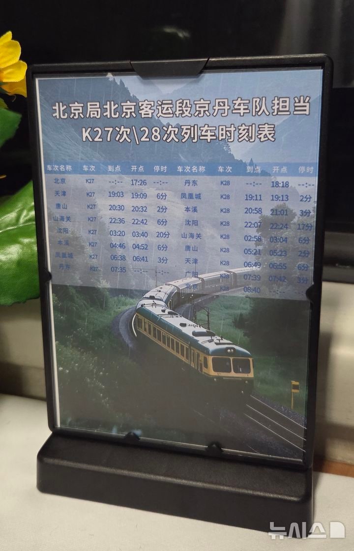 [베이징=뉴시스] 박정규 특파원 = 12일 북·중 간 여객열차 운행이 재개된 가운데 평양행 열차인 K27편 객실 내부 탁자에 중간 정착역과 시간표가 쓰인 안내판이 놓여있다.2026.03.13 pjk76@newsis