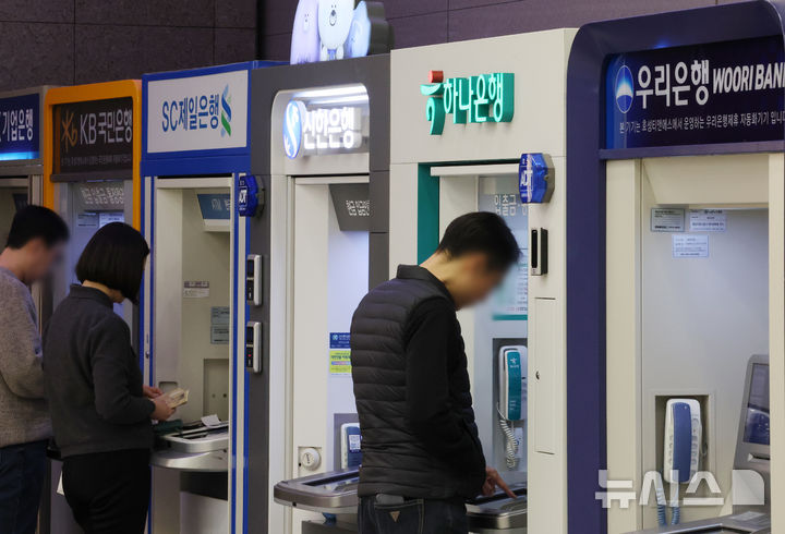 [서울=뉴시스] 조성우 기자 = 12일 서울 시내의 한 건물에서 시민들이 시중은행 ATM기기를 이용하고 있다.KB·신한·하나·우리·NH농협 등 5대 금융그룹은 지난해 당기순이익 20조 4700억 원을 기록하며 사상 