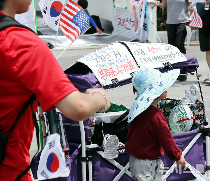 [서울=뉴시스] 박주성 기자 = 제9회 전국동시지방선거 투표용지 부족 사태에 항의하며 개표소 봉쇄 시위를 이어가고 있는 14일 서울 송파구 올림픽공원 핸드볼경기장에 설치된 개표소 앞에 한 시민들이 재선거 문구를 붙이
