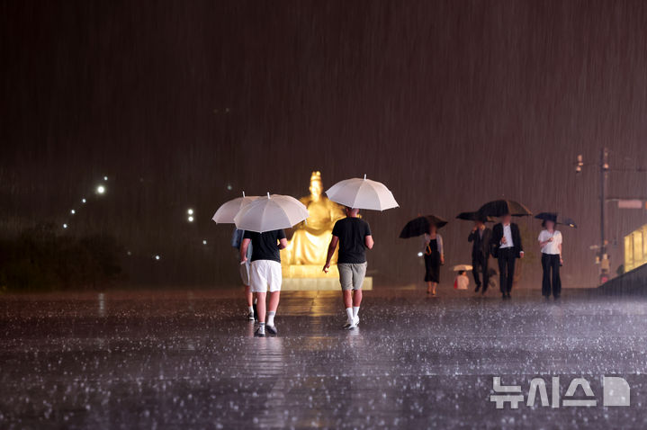 [서울=뉴시스] 홍효식 기자 = 비가 내리는 14일 오후 서울 종로구 광화문광장에서 시민들과 관광객들이 우산을 쓰고 발걸음을 재촉하고 있다.2026.07.14.