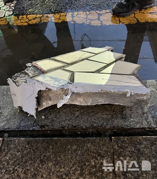 [서울=뉴시스] 김드보라 인턴기자 = 23일 오후 서울 종로구 한 건물 외벽에서 떨어진 콘크리트 파편이 사고 직후 인도에 떨어져 있다.2026.07.23.